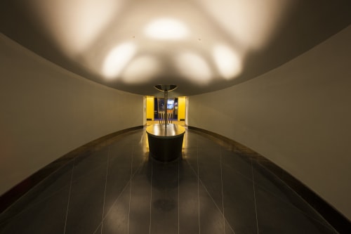 Oval room with dim lights and spotlights on ceiling