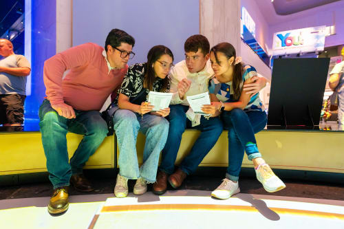 Guests in Museum Rotunda huddling and talking over a puzzle booklet