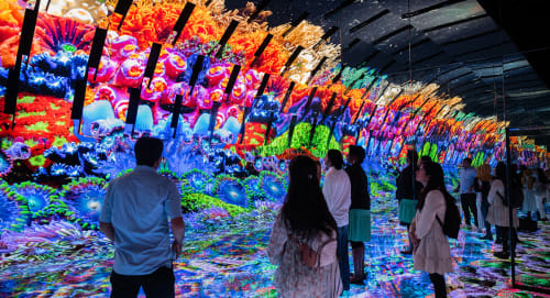 Guests standing before a tall multicolor video display