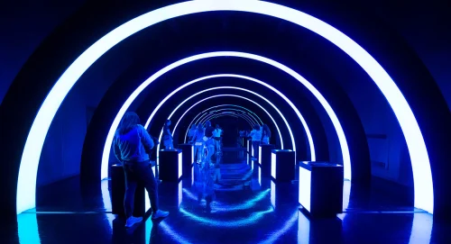 Long dark blue corridor with bright lit arches into distance