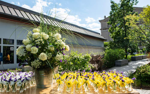 Outdoor table with rows of vases of flowers