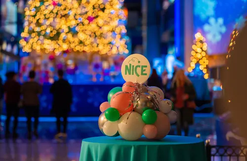 Table centerpiece with clustered ornaments and a badge reading "Nice"