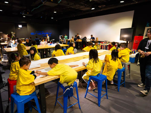 Young campers seated at tall tables and working