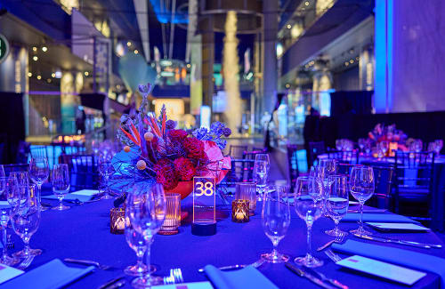 Table settings and floral centerpiece among Gala tables