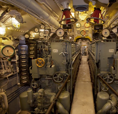 Engine room's dials, valves and controls, separated by narrow walkway
