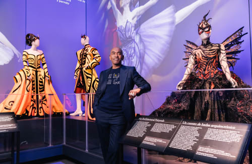Paul Tazewell poses in front of a variety of intricate costumes he designed for Sleeping Beauty the Ballet.
