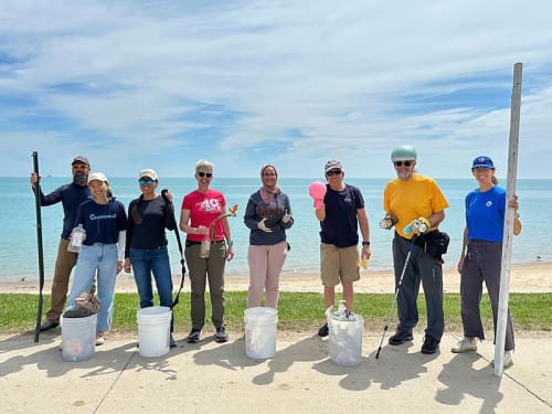 Group of volunteers at the lakeshore posing with collected recycling