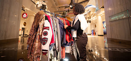 Woman browses rack of vintage clothing in the Transportation Gallery