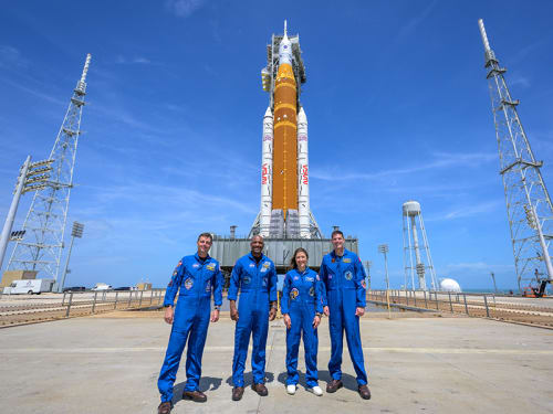 Artemis II crew pose with the Artemis II SLS (Space Launch System) rocket and Orion spacecraft on launching pad