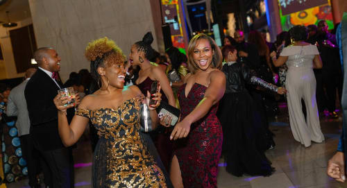 Attendees of an after hours event at Griffin MSI dance with drinks in hand.