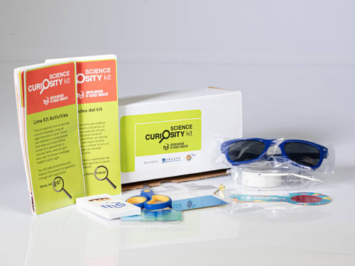 The contents of the "Lime" Science Curiosity Kit are displayed featuring activites like Red Reveal, Eyes in the Back of My Head, Magic Box, and Cipher Wheel and Cryptogram