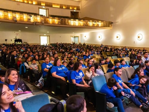 An auditorium filled with enthralled attendees of a Science Live assembly