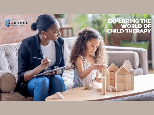 A child plays and builds a house with wood blocks while a child therapist looks and takes notes.