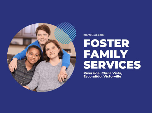 A foster family with a woman and two boys embracing and smiling together.