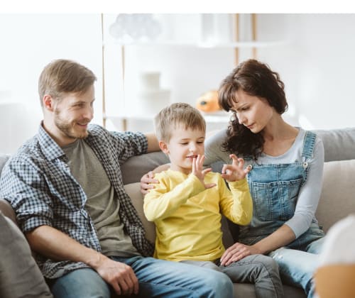 mom and dad listen to their young child talk in a family therapy session