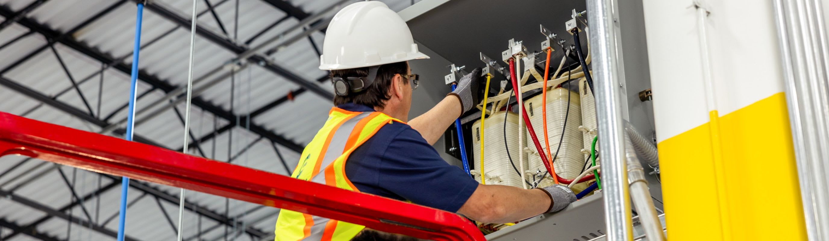 Connelly Electric service technician providing general electric maintenance in a hard hat and safety vest.