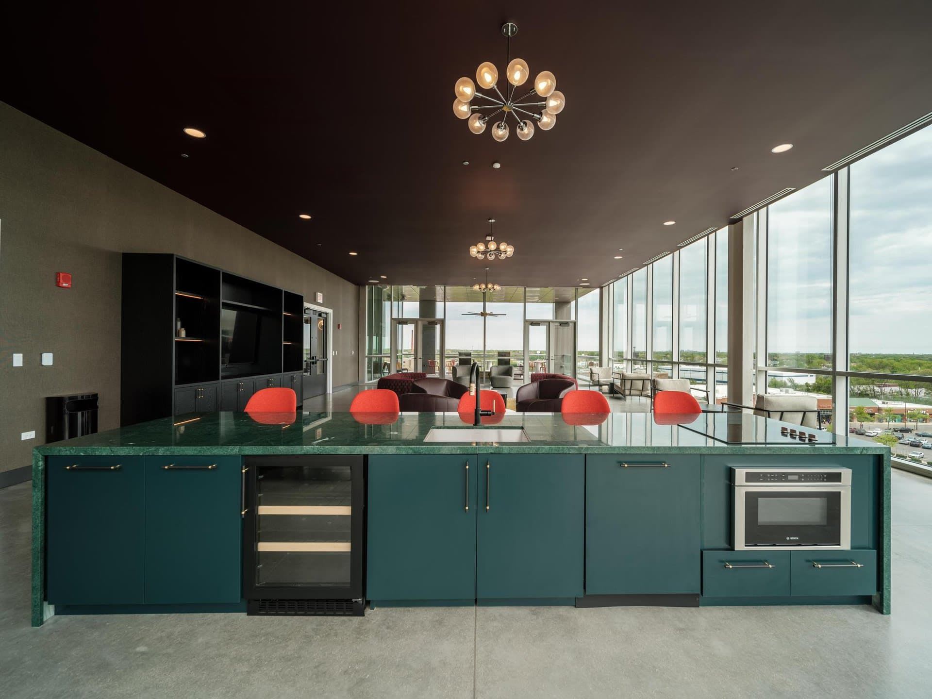 Kitchen space for residents with a sink, fridge, oven and green countertops and cabinet space.