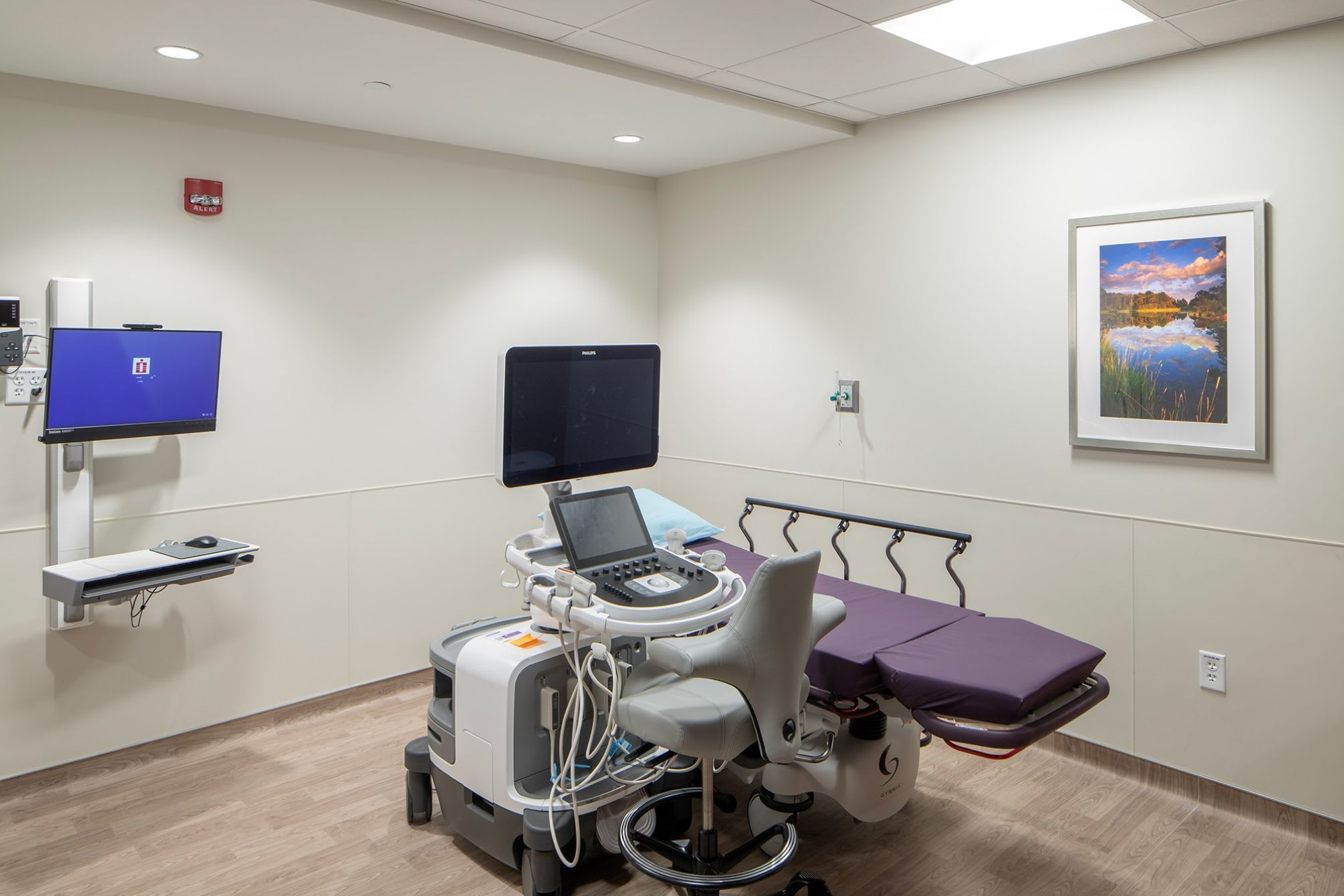 A room showing an ambulatory bed and two screens.