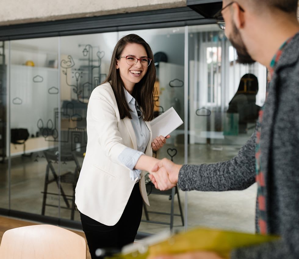 a hiring manager shaking hands with an interviewee