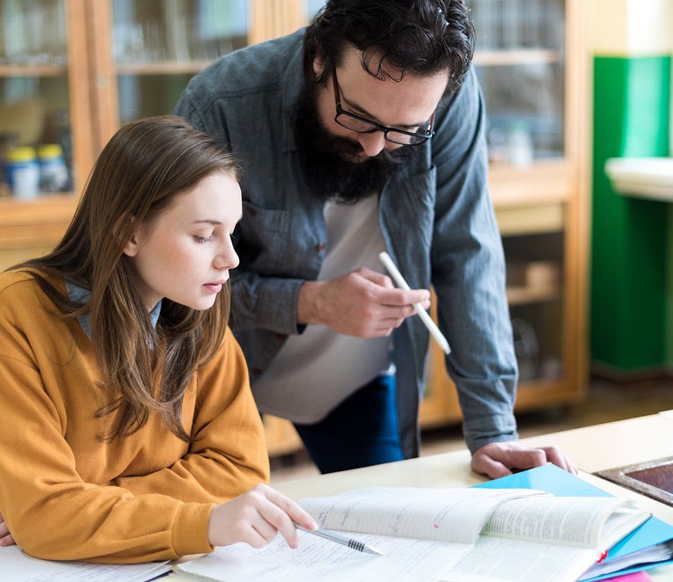 teacher helping a student with a question at school