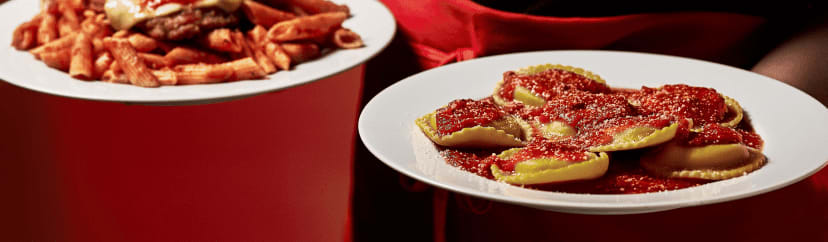 A plate of ravioli and a plate of mostaccioli from Beggars Pizza