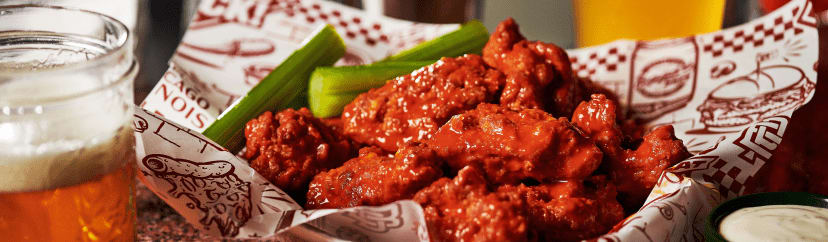 Beggars Pizza chicken wings with sauce and celery.