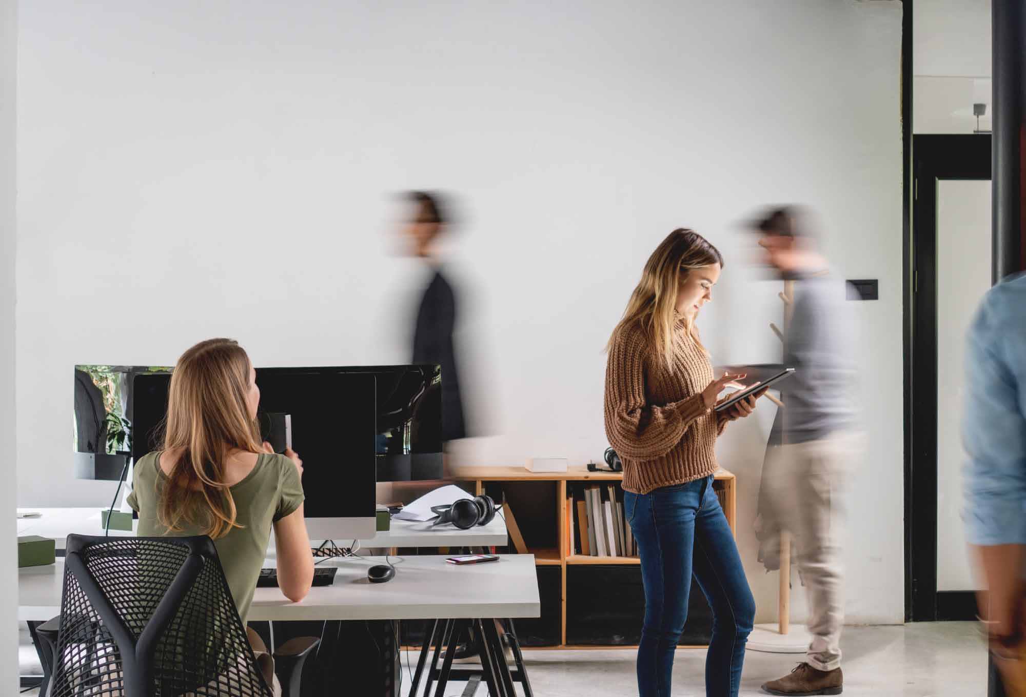 Employees working at an office. | Employee Growth and Development Ideas for “The Great Reshuffle” | Impact