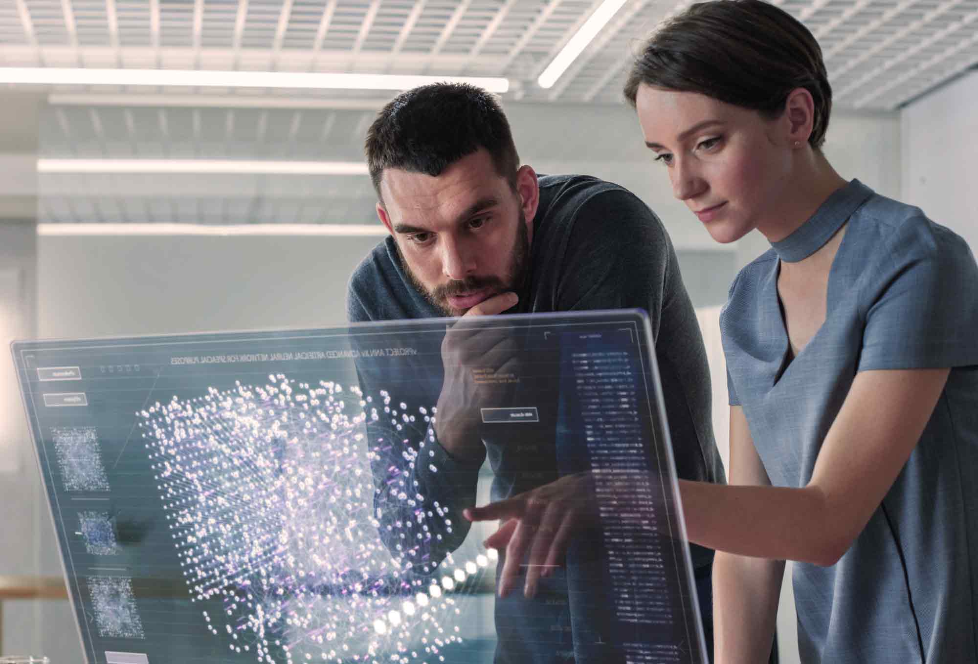 two people looking at a futuristic transparent screen