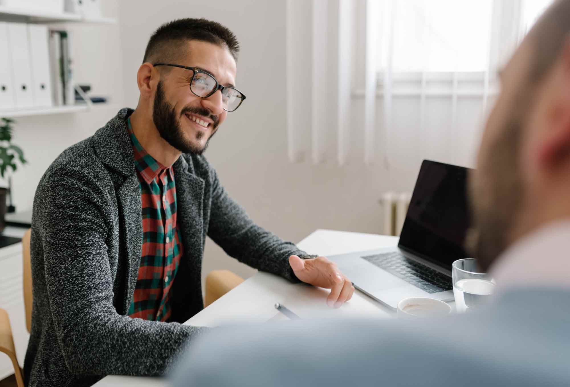 Smiling man conducting an interview in an office