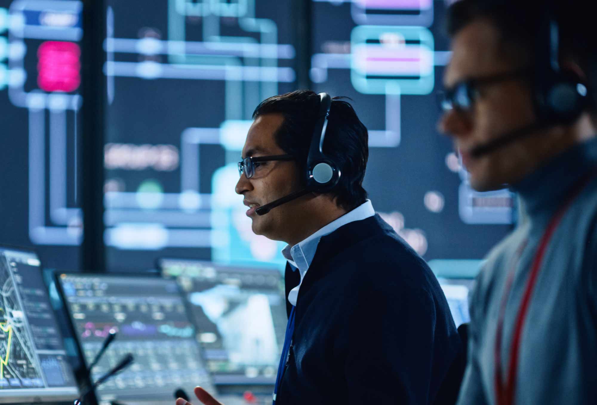 Two cybersecurity analysts in a room full of cybersecurity tech | Cybersecurity talent shortage | Impact