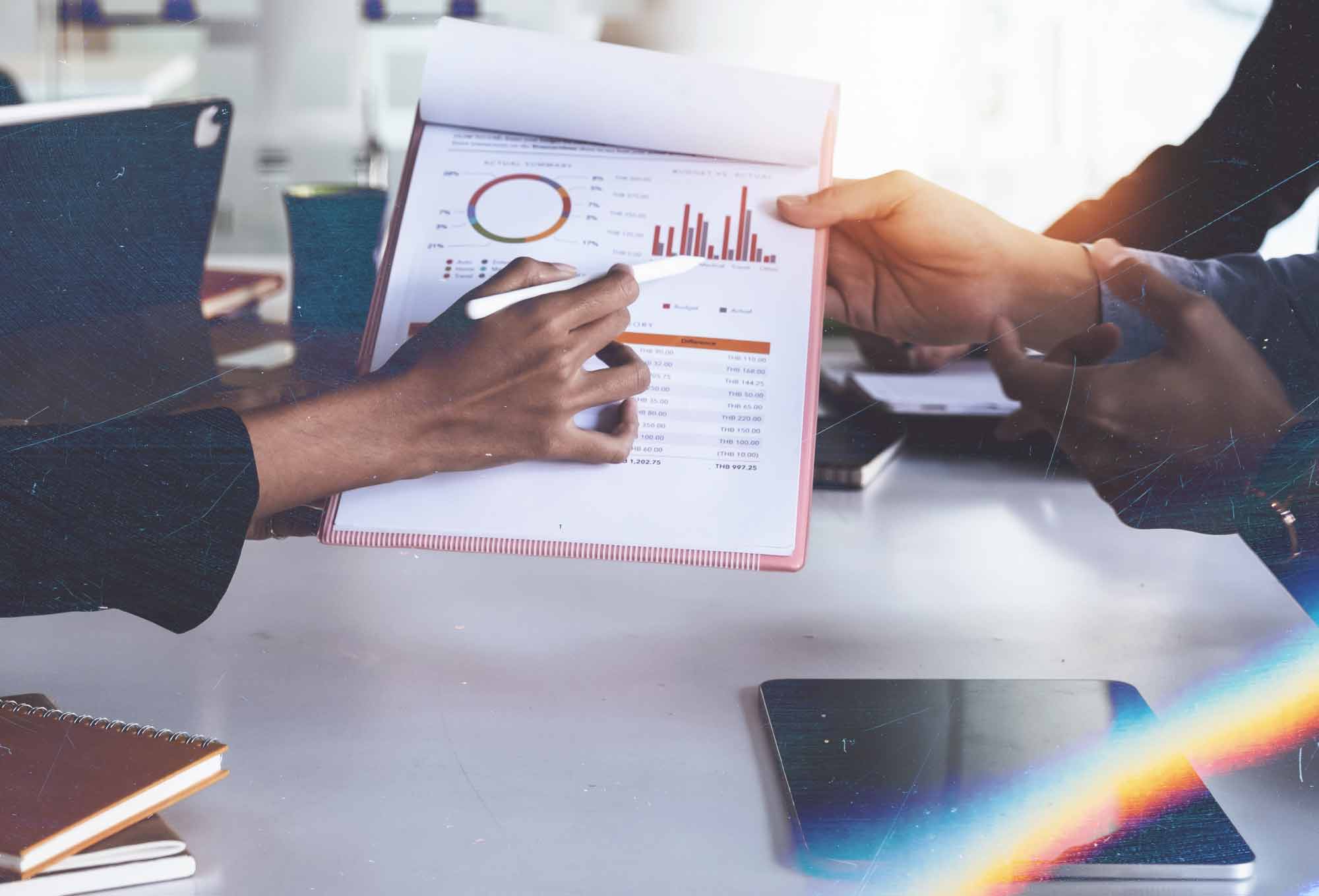two people working with graphs and charts at a desk