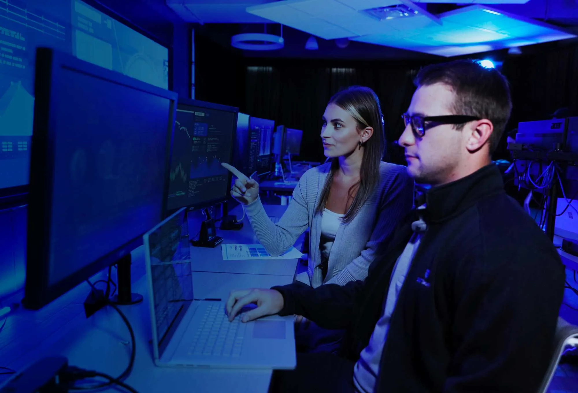 cybersecurity case study | two people looking at a computer in a blue-tinted photo