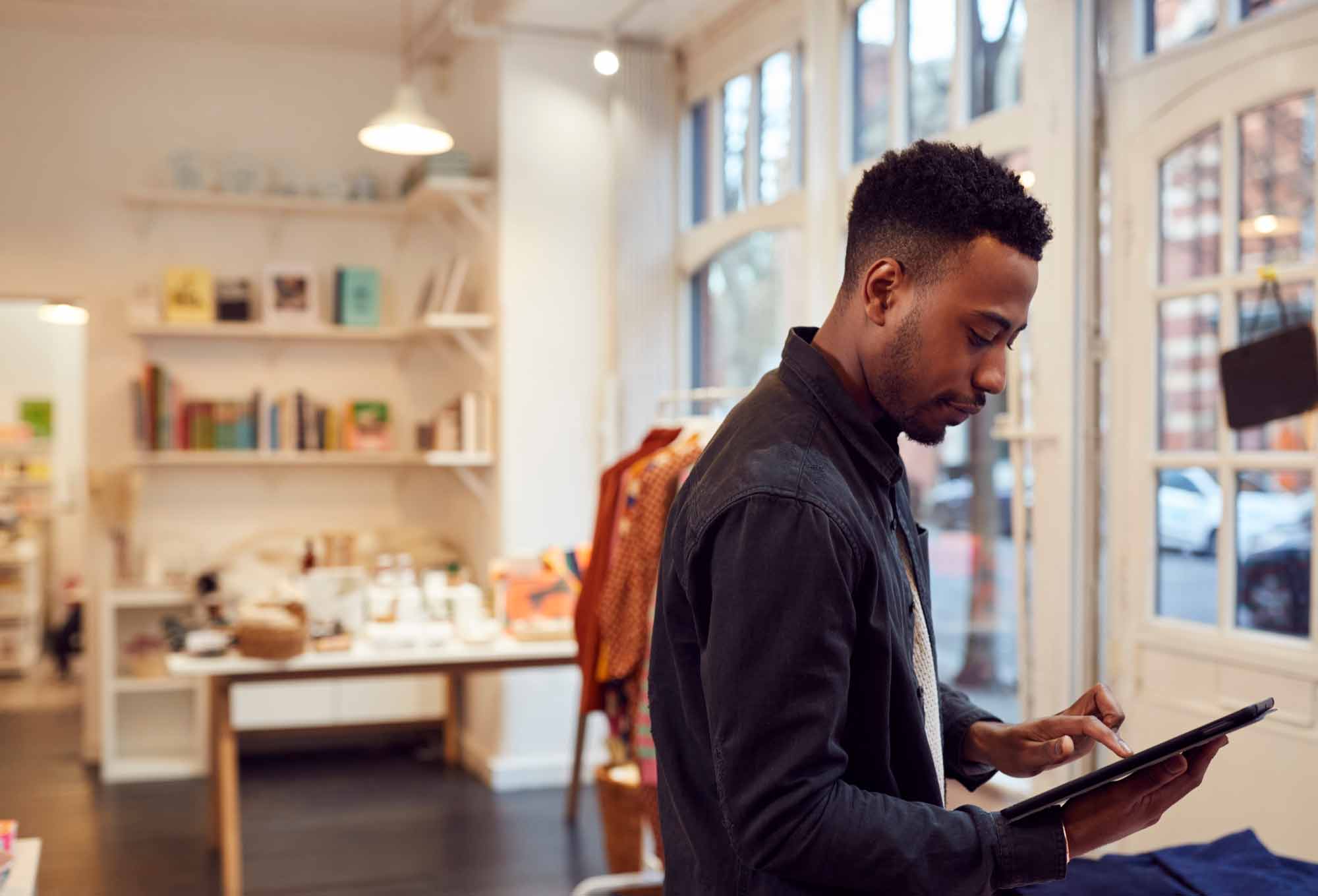 man working on ipad in storefront