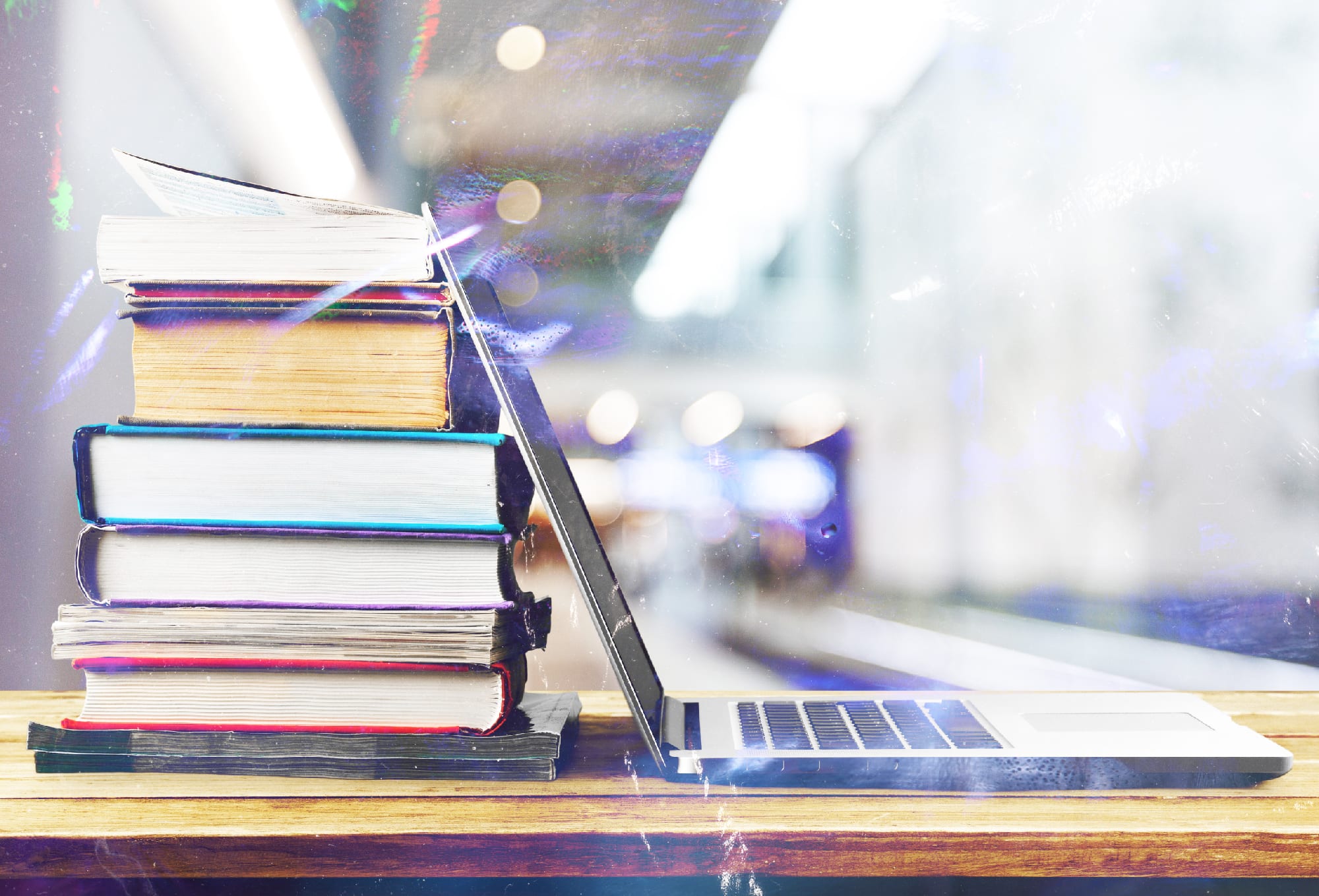 stack of books sitting next to a laptop