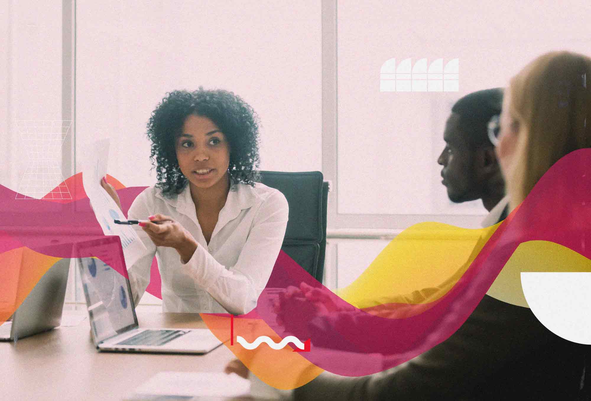 woman talking with pen and paper to two other people in room with chairs