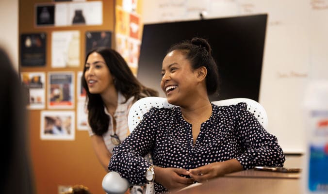 two team members laughing together