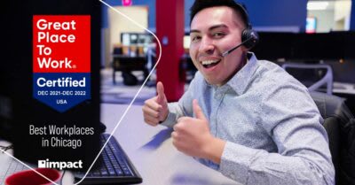Male Employee Sits at Desk and Smiles with Great Place to Work Certification Badge Overlay