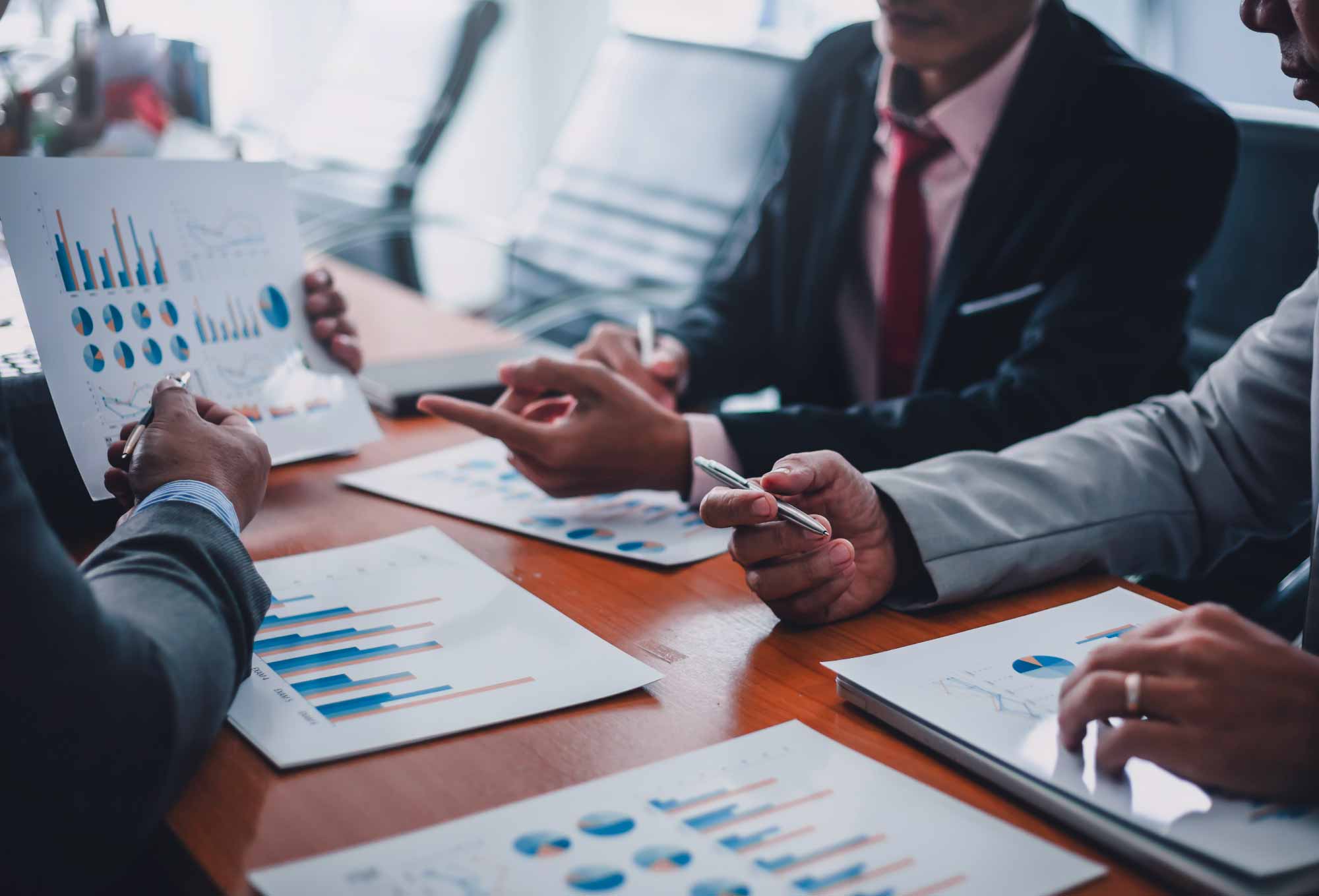 people in suits discussing paperwork