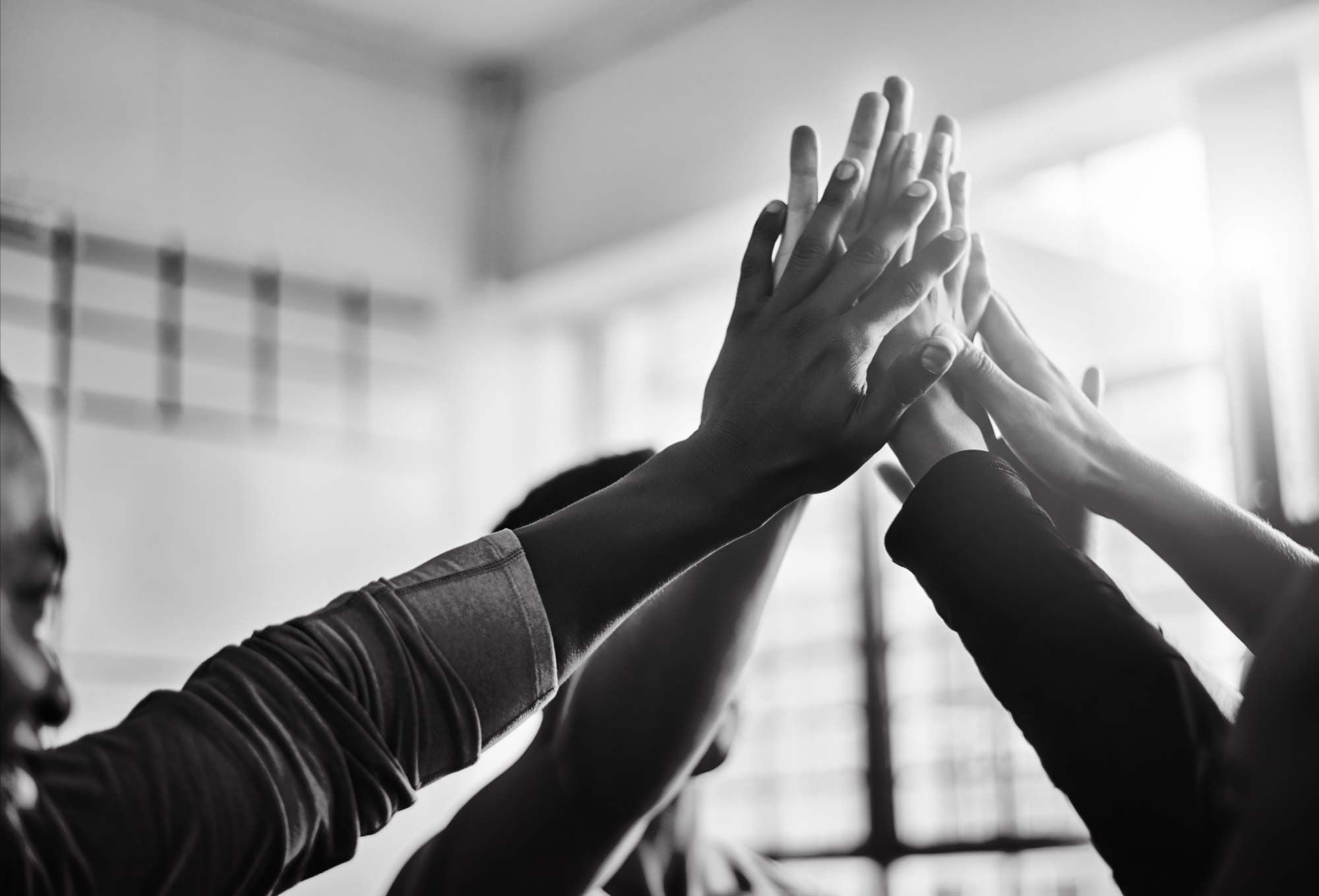 Team putting hands together for big high five.