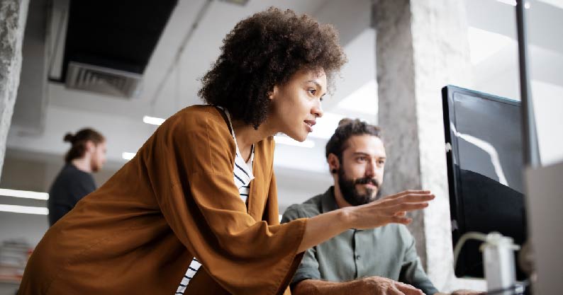 woman talking to a man pointing to a laptop