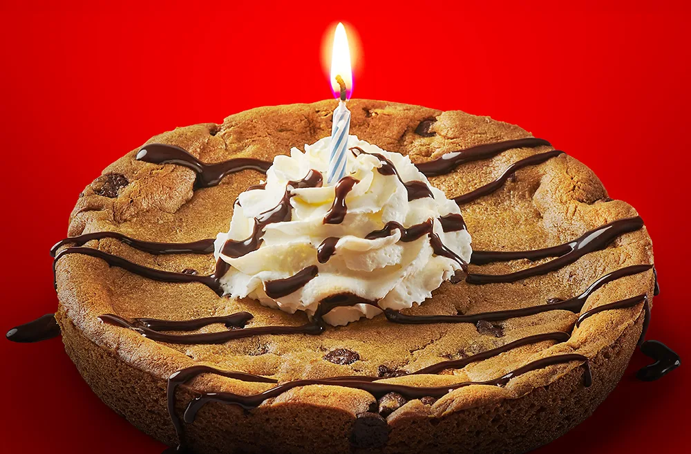 A cookie cake with a birthday candle on it