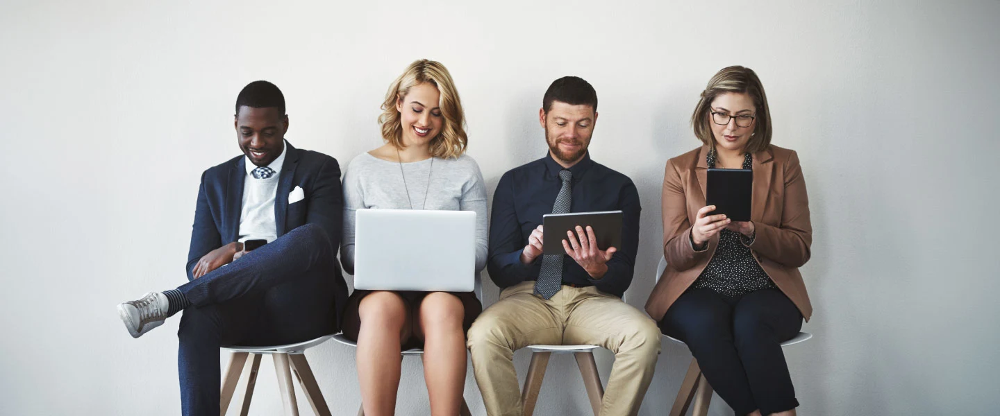 A group of professionals sitting in a line against a wall