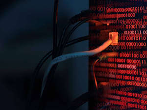 A series of cables plugged into a computer case with binary code scrolling along the side