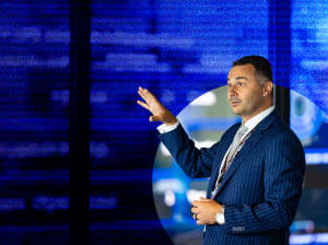 man giving presentation in front on blue | how to hack your business cybersecurity webinar