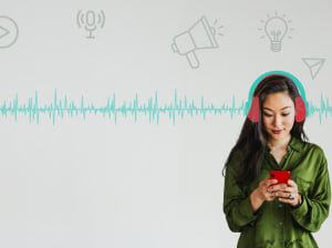 A woman stands and holds her phone with both hands, looks down at the screen and has headphones drawn on