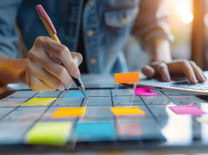 person writing on colorful sticky notes