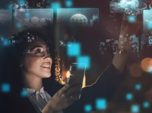 A woman holding a phone and working on a digital smart display