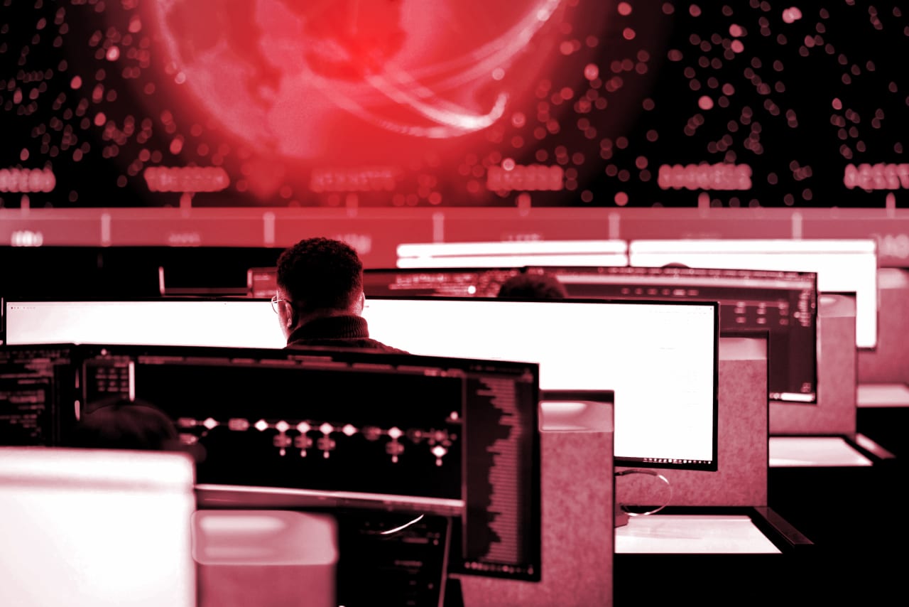 Man sitting behind two computer screens