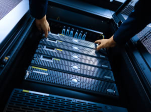 A pair of hands working on a server stack