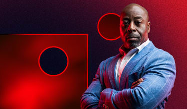 Businessman in blue suit with crossed arms standing powerfully in front of Impact Networking logo